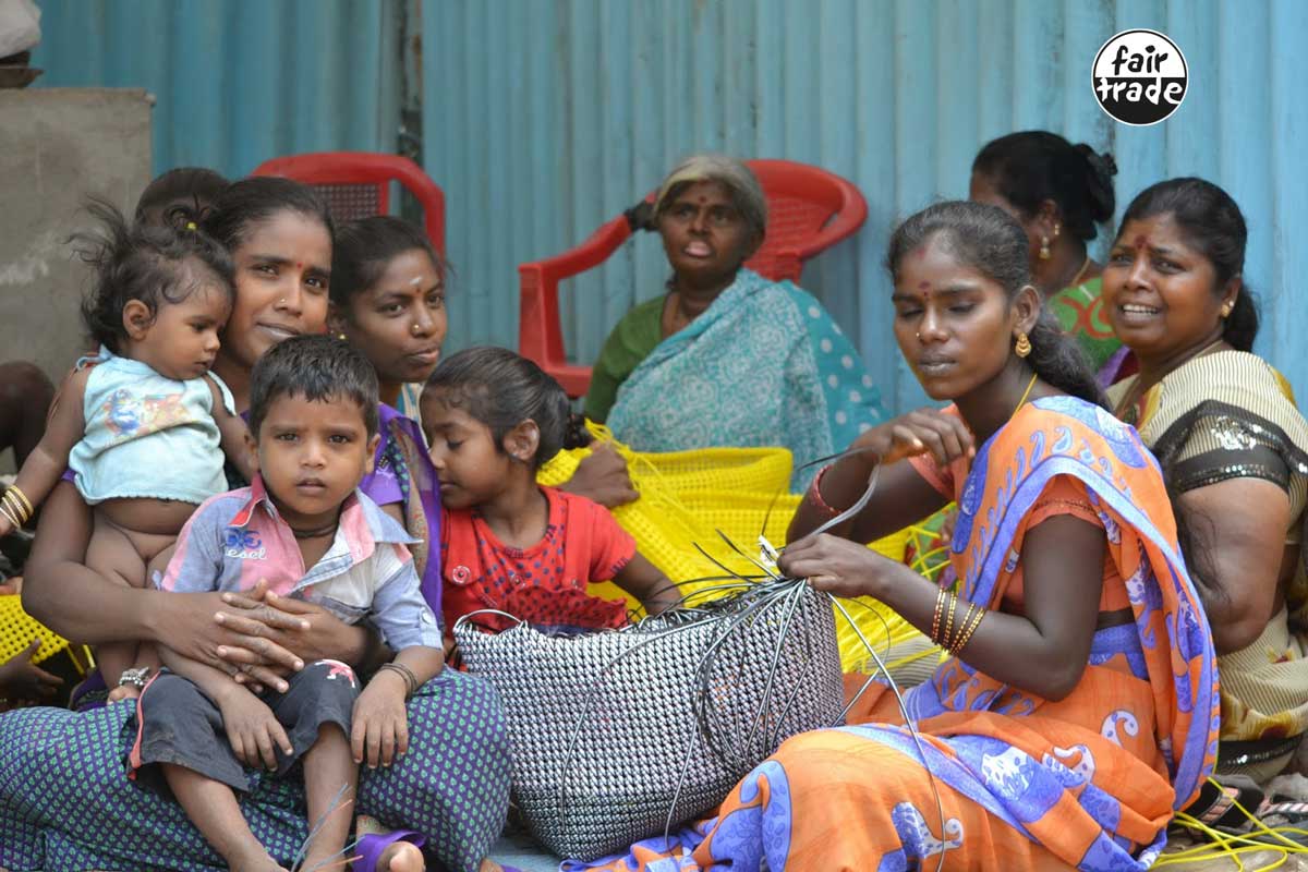 Kvinde fra Indien sidder med deres børn og fletter RainTree taske